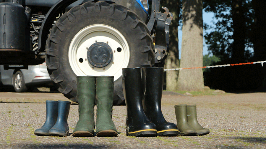 Vier Paar Gummistiefel stehen vor einem Traktor auf dem Boden. Bild: Gerda von Lienen LWK Niedersachsen